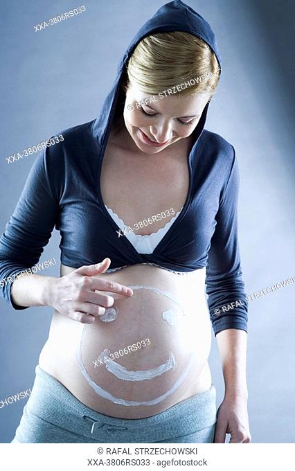 pregnant woman with cream on belly
