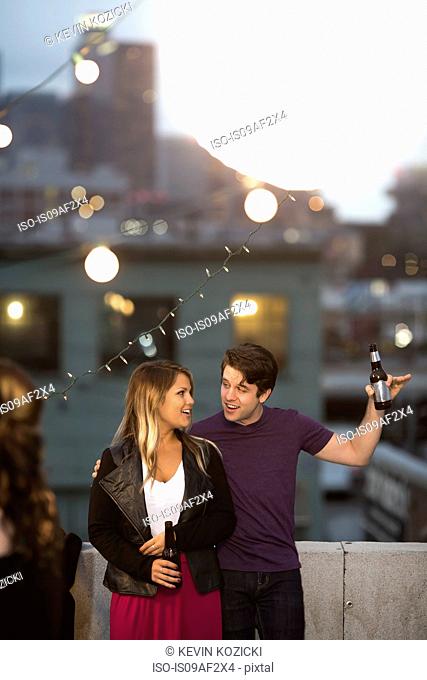 Young couple flirting at rooftop barbecue