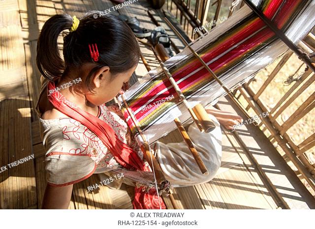 A little girl learns the art of weaving on a hand loom, Chittangong Hill Tracts region, Bangladesh, Asia