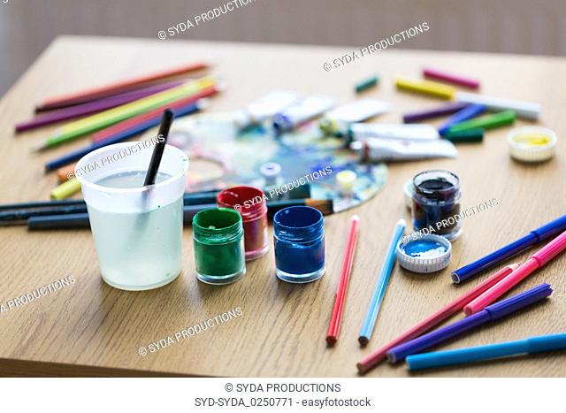 gouache colors, felt tip pens and pencils on table