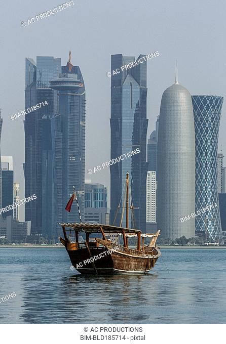 Boat floating near Doha skyline, Doha, Qatar