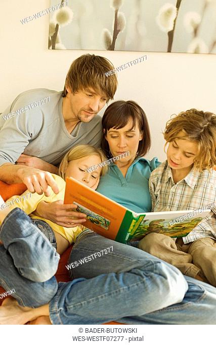 Family reading story book in living room