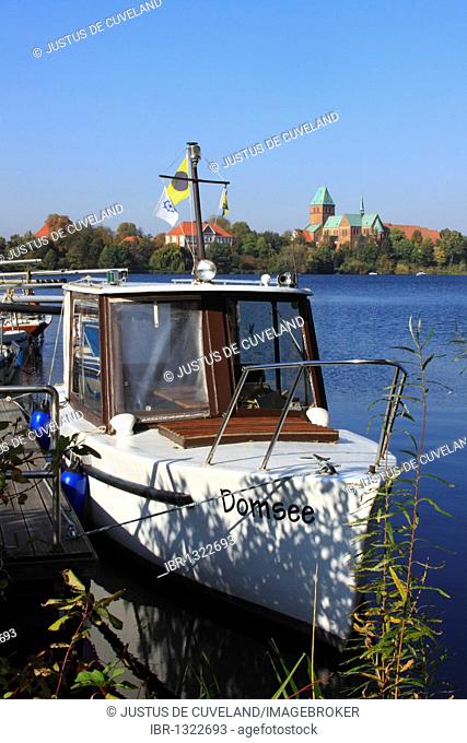 Boat on Domsee Lake in front of Ratzeburg Cathedral and Herrenhaus, now the Regional Museum, on Dominsel island, Ratzeburg, Duchy of Lauenburg