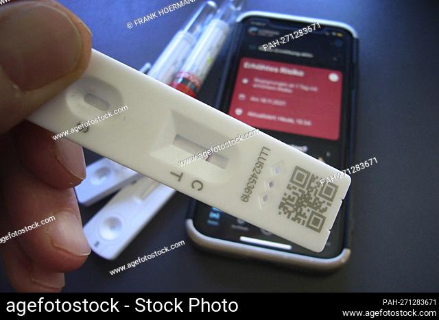Topic image: Corona quick test after risk encounter (symbolic photo). The Corona Warn app on a smartphone shows increased risk