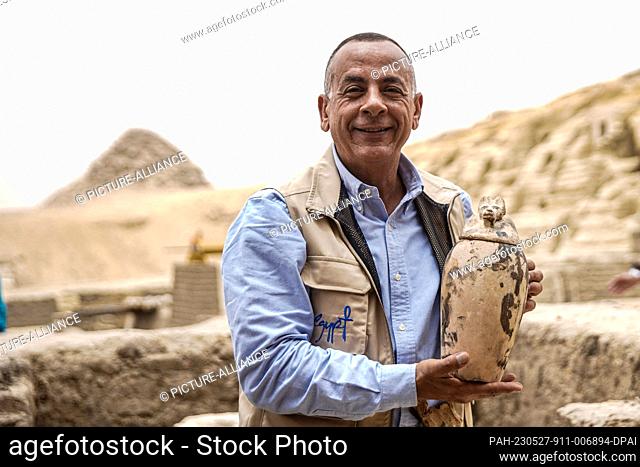 27 May 2023, Egypt, Saqqara: Mostafa Waziri, head of Egypt's Supreme Council of Antiquities, hols a ritual vessels used for mummification during the...