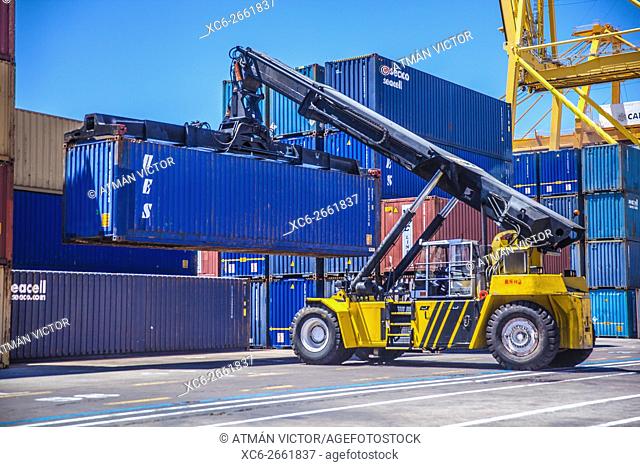 reach stacker lifting containers in a dock