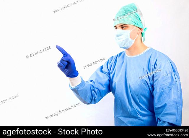 Surgeon doctor in sterile gloves preparing for operation in hospital. He is wearing surgical cap and blue gown