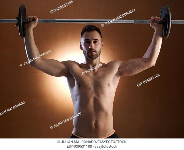 Young man training with weight lifting