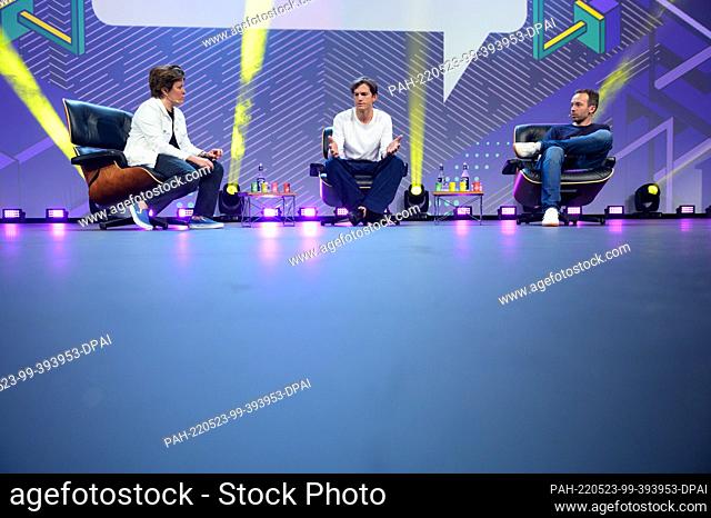 18 May 2022, Hamburg: Actor Ashton Kutcher (M) gestures during his appearance next to journalist Kara Swisher (L) and OMR CEO Philipp Westermeyer (R)