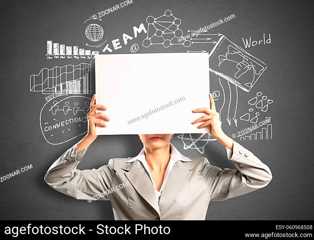 Businesswoman hiding her face behind sheet of paper