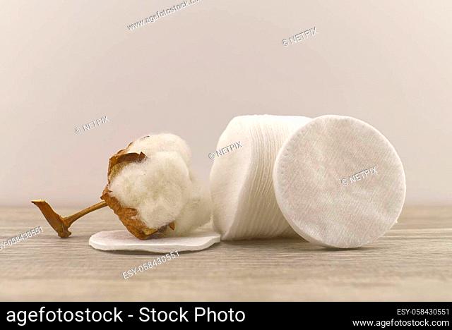 Raw cotton boll and stack of makeup remover pads. Concept of natural cotton products