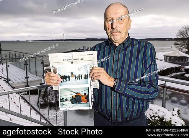 10 February 2021, Schleswig-Holstein, Eckernförde: Ulrich Cramer is standing on his terrace holding photos and a newspaper article in his hands
