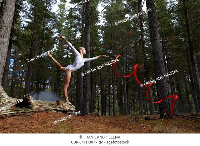 Dancer twirling ribbon in forest
