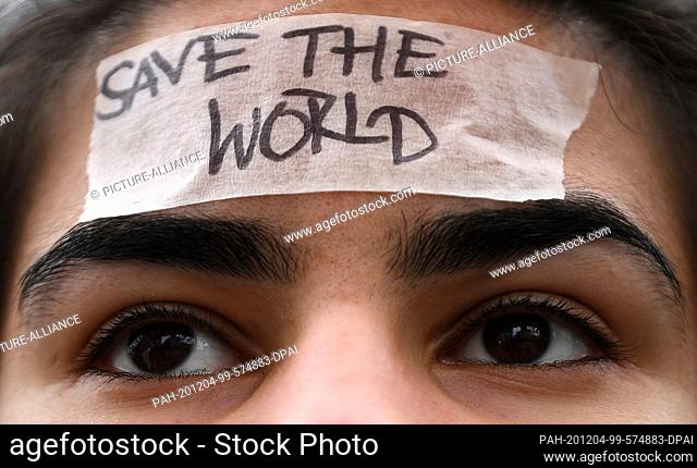 15 March 2019, Saxony-Anhalt, Halle (Saale): During the demo ""Fridays for Future"" a schoolgirl wears a ribbon with the inscription ""Save the World"" on her...