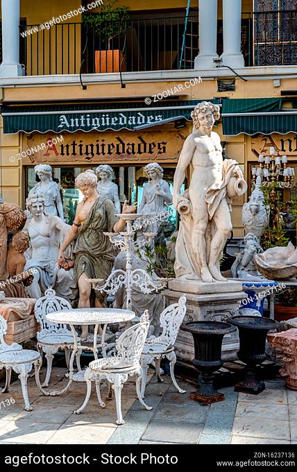 Madrid, Spain - October 20, 2020: Classic sculptures and garden furniture in antique store in El Rastro in Latina quarter in Central Madrid