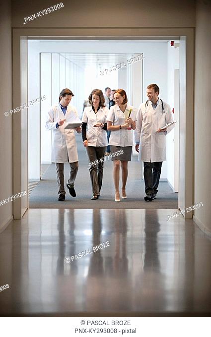 Four doctors walking at the corridor of a hospital