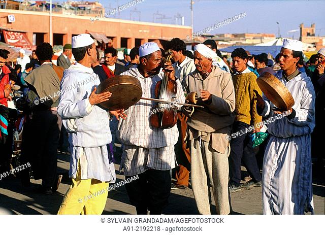 MOROCCO.SOUTH.MARRAKECH.JEMAA-EL-FNAA SQUARE.GNAOUA DANCERS AND MUSICIANS PERFORMING