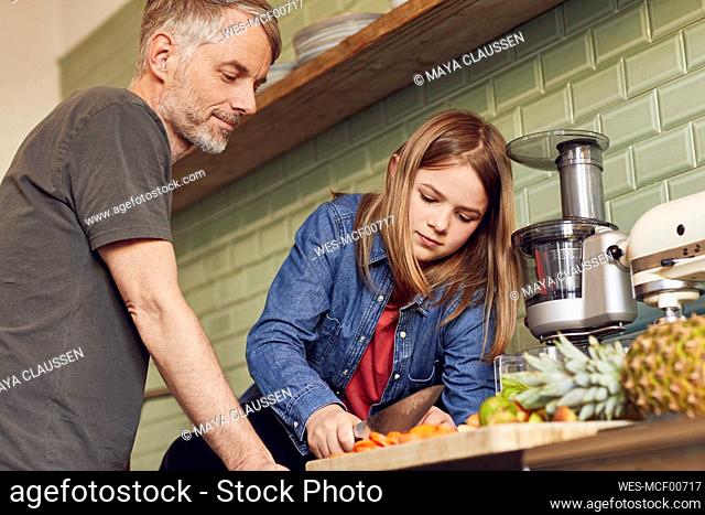 Father and daughter in kitchen preparing fruit and vegetables