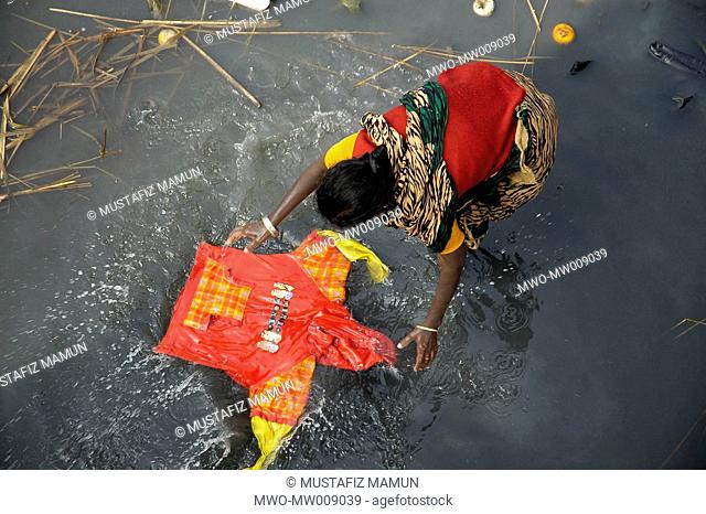 A woman washing clothes in the polluted water of the Buriganga River Dhaka, Bangladesh February 11, 2007