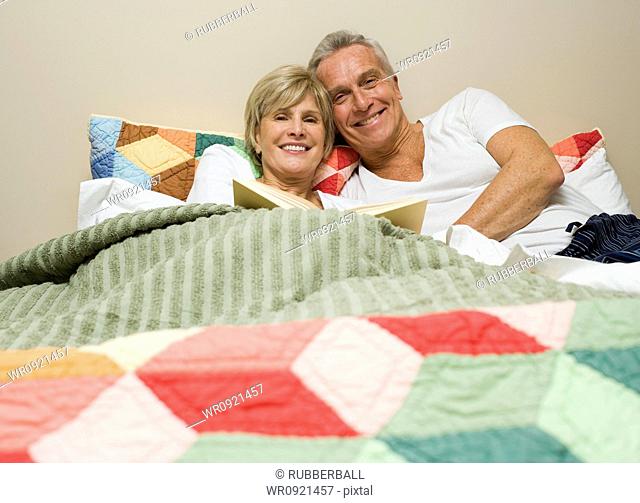 Mature couple in bed reading