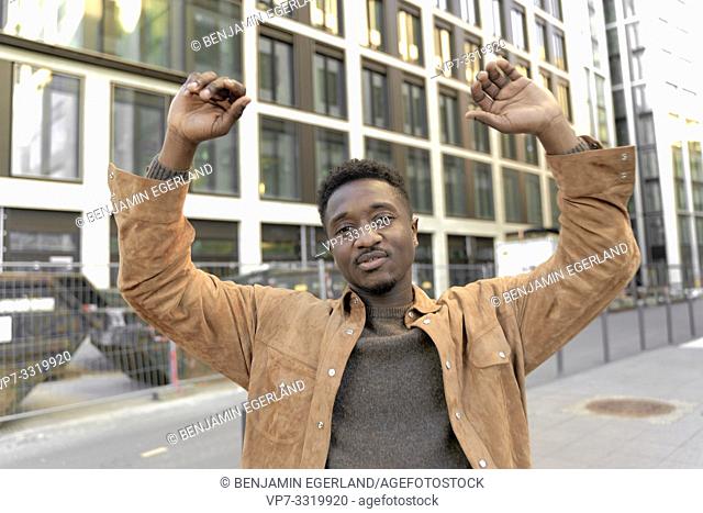 African man with arms up in city, in Frankfurt, Germany