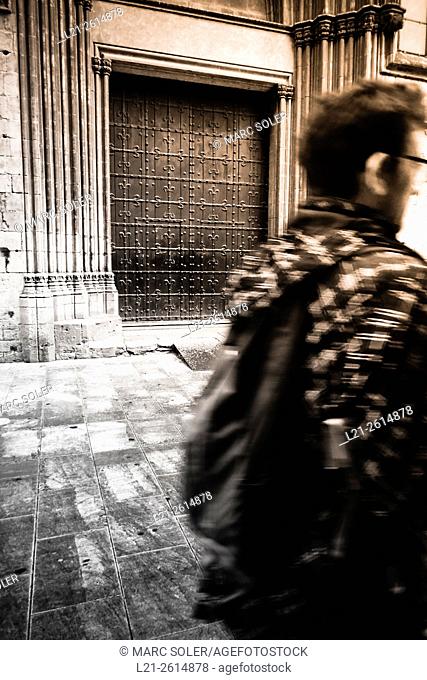 Young man walking with backpack. Santa Maria del Mar Church, Ribera district, Barcelona, Catalonia, Spain