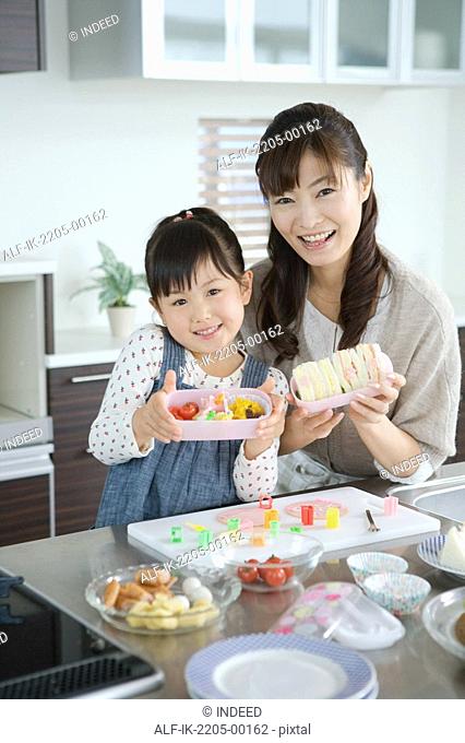 Mother with daughter packing lunch box