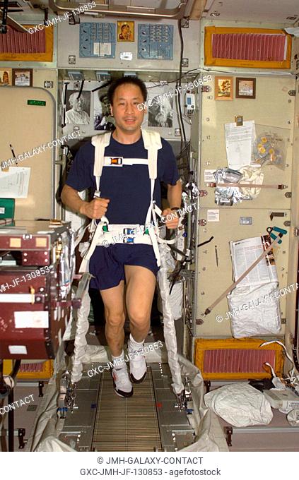 Astronaut Edward T. Lu, Expedition 7 NASA ISS science officer and flight engineer, exercises on the Treadmill Vibration Isolation System (TVIS) in the Zvezda...