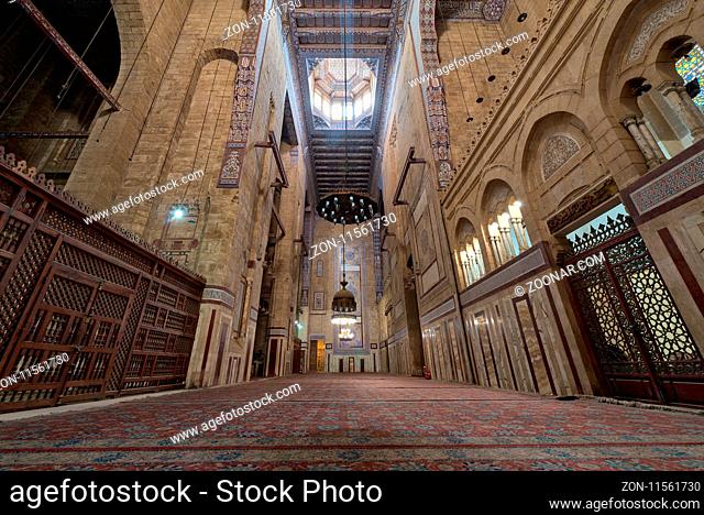 Cairo, Egypt - December 16 2017: Interior of al Refai mosque with old decorated bricks stone wall, colored marble decorations, wooden ornate ceiling