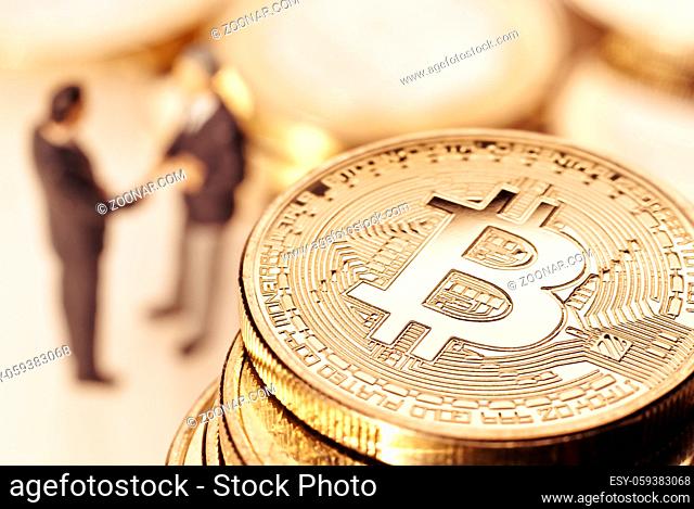 Bitcoin Münze und Geschäftsmänner im Hintergrund, die sich die Hände reichen