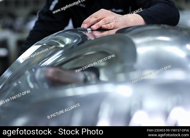 03 April 2023, Saxony, Schwarzenberg: An employee of Porsche Werkzeugbau GmbH pulls off a tool with a diamond grinder. Forming tools have been manufactured at...