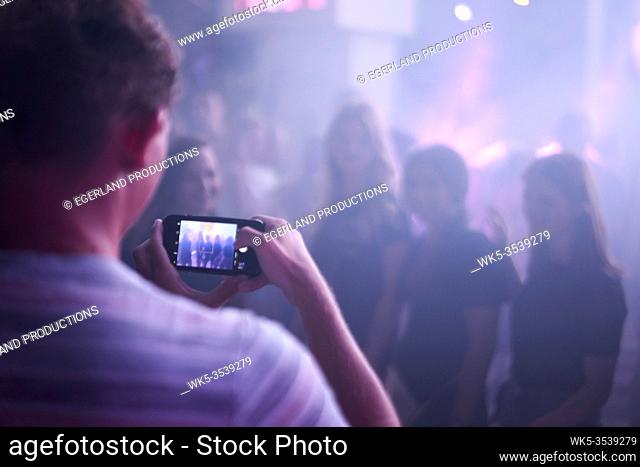 taking smartphone photo at party in night club