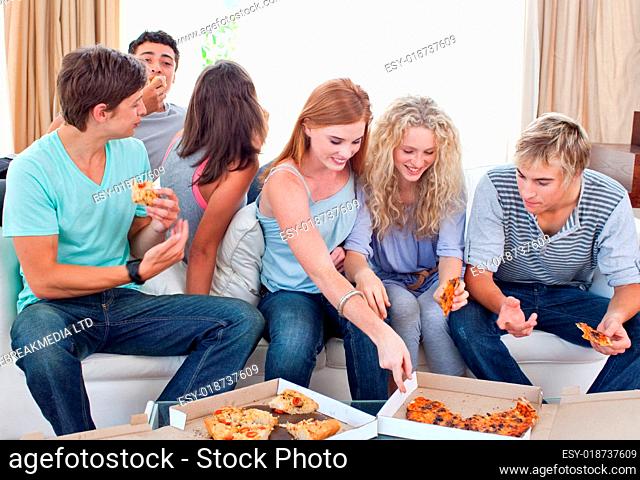Adolescents eating pizza at home