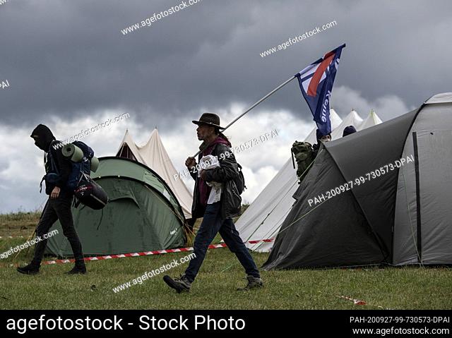 27 September 2020, Hessen, Dannenrod: Two activists walk through a tent camp towards the forest. Hundreds of activists have been protesting here for months...