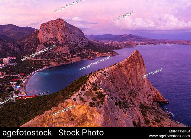 pink sunset in novyi svit in autumn with mount falcon in background. sudak, the republic of crimea. aerial view