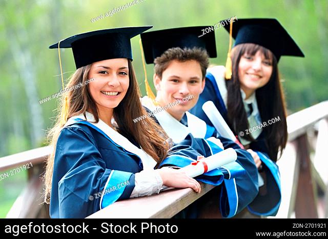 group of three graduation students in the park cheerful and happy