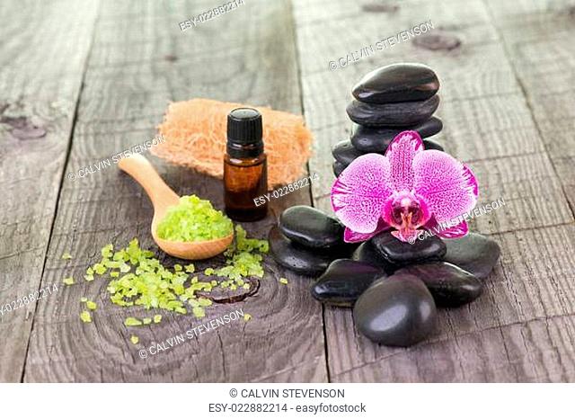 Orchid, bath salt, essential oil and black stones close-up