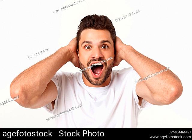 Portrait of young man with shocked facial expression, isolated over white background