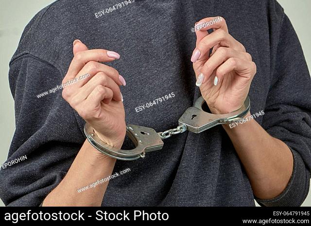 women's hands are handcuffed in close-up. High quality photo