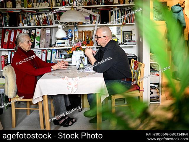 PRODUCTION - 14 February 2023, Berlin: Helga Müller and Jan Römmler chat at the dining table during a visit. Under the motto ""Young meets Old""