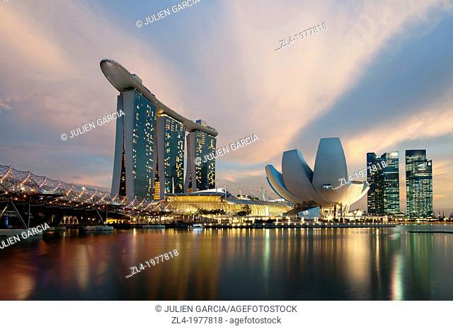 Marina Bay Sands hotel at sunset with the ArtScience museum designed by the architect Moshe Safdie, the helix bridge on the left