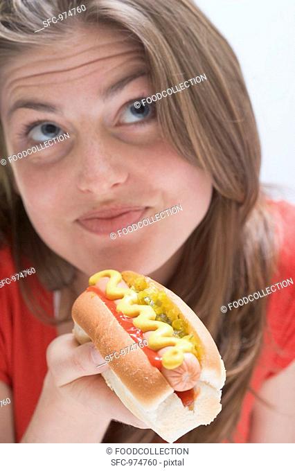 Pensive woman with hot dog