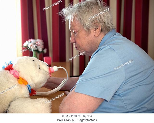 Johanna Kraus (89 years old) pets a cuddle robot called 'Ole' at the retirement home for people with dementia 'Haus O'land' in Bremen, Germany, 24 July 2013