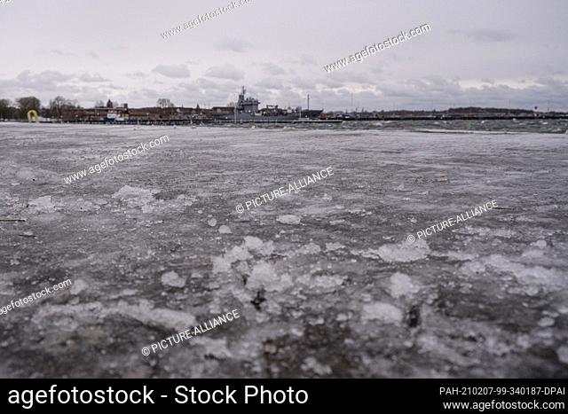 07 February 2021, Schleswig-Holstein, Strande: A sidewalk is iced over after water from the Baltic Sea overflowed the shore
