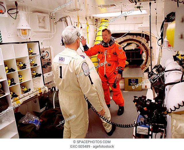 02/11/2000 --- STS-99 Pilot Dominic Gorie appears to wave while the closeout crew in the White Room checks his launch and entry suit before he enters orbiter...