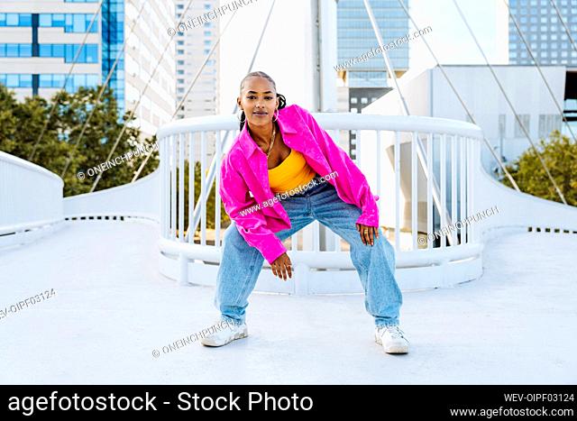 Confident young dancer breakdancing on footbridge