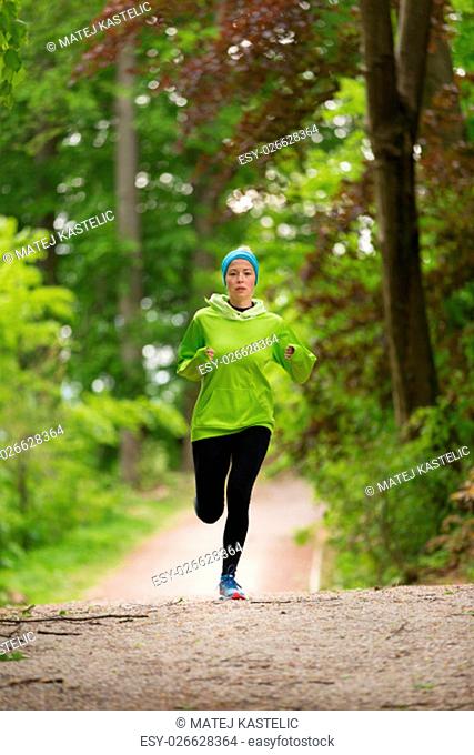 Sporty young female runner in forest. Running woman. Female runner during outdoor workout in nature. Fitness model outdoors. Weight Loss