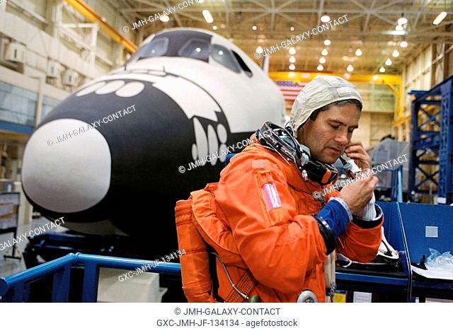 Astronaut Paul S. Lockhart, STS-113 pilot, dons a training version of the full-pressure launch and entry suit prior to the start of a training session in the...