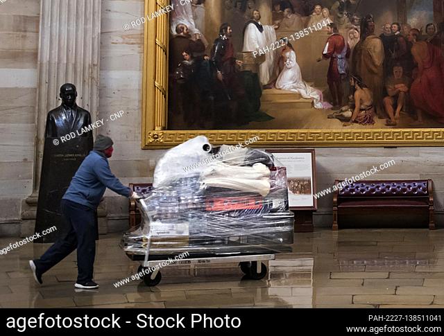 Workers wheel dinner in to-go bags and beverages through the U.S. Capitol Rotunda and into the office of Speaker of the United States House of Representatives...