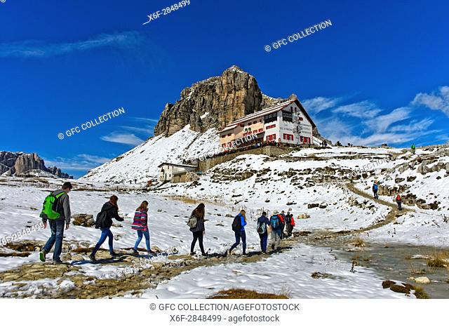 Hikers on the way to the Dreizinnenhütte, Rifugio Locatelli hut, snow-covered peaks Sextener Stein, Sasso di Sesto, and Tower of Toblin, Torre di Toblin